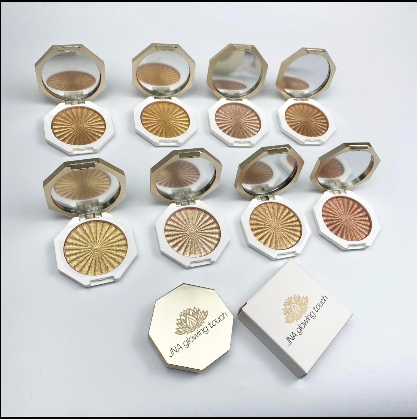 JNA glowing touch highlighter in gold and bronze compact form.