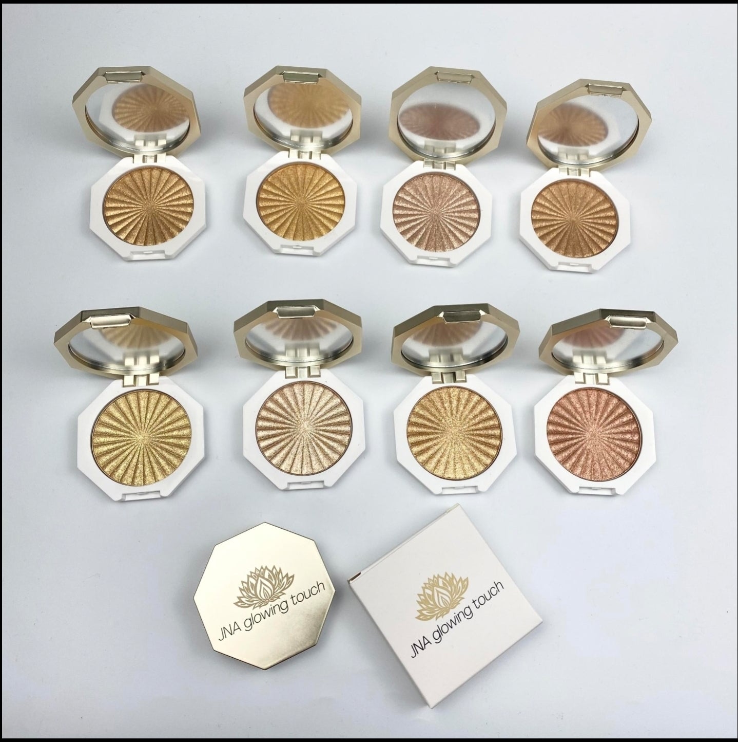 JNA glowing touch highlighter in gold and bronze compact form.