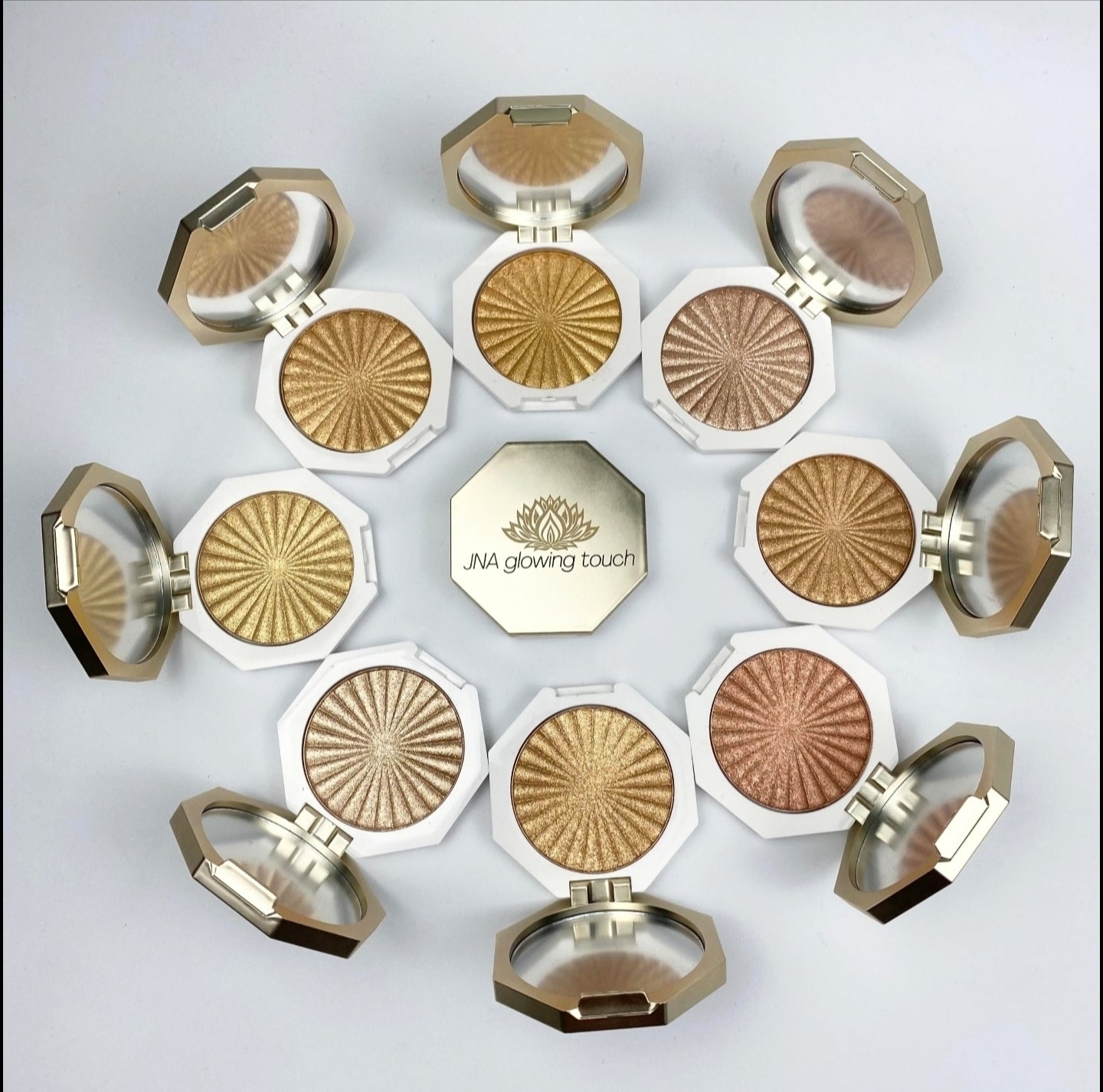 JNA glowing touch highlighter in gold and bronze compact form.