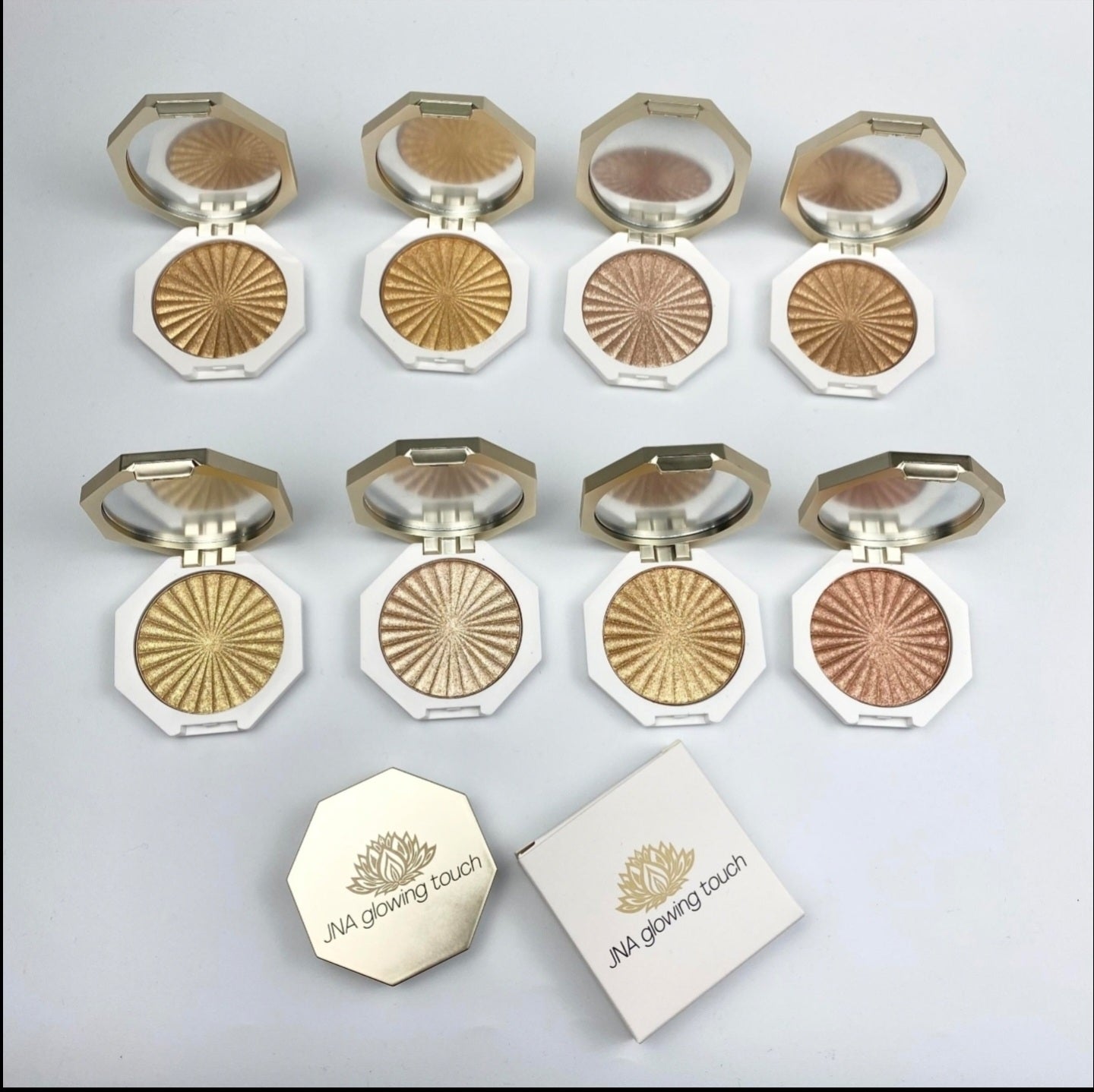 JNA glowing touch highlighter in gold and bronze compact form.